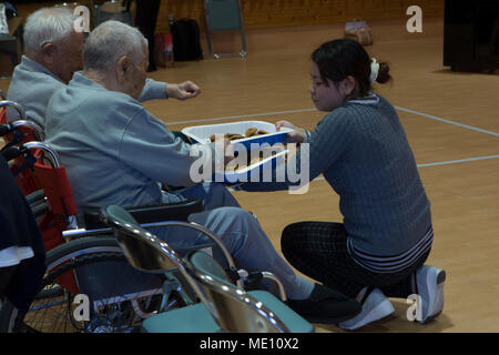 NAGO, Okinawa, Japan - ein Mitarbeiter fließt aus Cookies Dez. 15 in der Okinawa Airakuen Sanatorium in Nago, Okinawa, Japan. Freiwillige aus dem militärischen Gemeinschaft Chocolate Chip Cookies und das Bananenbrot zu übergeben werden, während Service Mitglieder sang. Seit 1938, der nago Airakuen Sanatorium hat ein Erholungsheim für Leprakranke oder ex-Leprakranke. Service Mitglieder aus ganz Okinawa zusammen Norden zu reisen, ihren Geist von Weihnachten mit einem älteren Gruppe lebt im Sanatorium zu teilen. (U.S. Marine Corps Foto von Lance Cpl. Danielle R. Prentice) Stockfoto