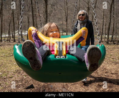 Großmutter und Enkelin spielen in Kunststoff swing Stockfoto