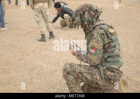 Eine nationale afghanische Armee Soldat mit 215 Corps bindet einen Abriss kostenlos an eine Amtsleitung im Camp Shorabak, Afghanistan, 26.12.2017. Rund 20 Techniker Soldaten ausgeführt ein Abriss Bereich, besteht Explosionsgefahr, Reduzierung der Kurs unter der Leitung von US-Beratern abgeschlossen. Die vierwöchige Schulung Evolution findet die Studenten aus der Route Spiel auf und unterrichtet sie die ordnungsgemäße Entsorgung Methoden der Improvised Explosive Devices, anschließend die Verbesserung der Mobilität der Truppen und der Lieferungen auf dem Schlachtfeld in der Provinz Helmand. (U.S. Marine Corps Foto von Sgt. Lucas Hopkins) Stockfoto