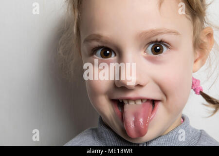 Glückliche kleine Mädchen ihre Zunge zeigen. Stockfoto