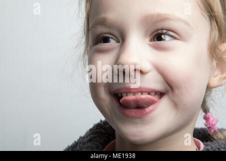 Glückliche kleine Mädchen ihre Zunge zeigen. Stockfoto