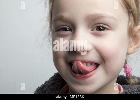 Glückliche kleine Mädchen ihre Zunge zeigen. Stockfoto