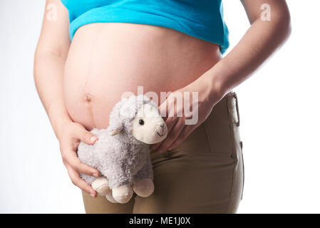 Pregnat Frau Bauch holding Spielzeug schließen bis auf weißem Hintergrund Stockfoto