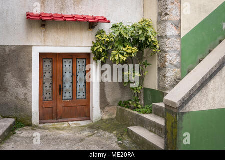 Eingang eines Hauses in Buenos Aires (Insel Cres, Kroatien), rotes Vordach an einem bewölkten Tag im Frühling Stockfoto