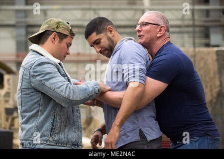 Komiker und Schauspieler Adam Devine handschellen Küchenchef Robert Irvine zu Ehrenmedaille Empfänger pensionierte Armee Kapitän Florent "Flo" Groberg während des Vorsitzenden Holiday Tour für Service Mitglieder am Flughafen Bagram, Dez. 24, 2017. Dunford und Troxell, zusammen mit USO Animateure, besuchte Service für Mitglieder, die während der Feiertage bereitgestellt werden. Animateure sind in diesem Jahr die Küchenchef Robert Irvine, Wrestler Gail Kim, Comedian Iliza Shlesinger, Schauspieler Adam Devine, Land Musiker Jerrod Niemann, und WWE Superstars" Die Miz" und Alicia Fox. (DoD Foto von Marine Petty Officer 1st Class Dominique A. Pineiro/Freigegeben) Stockfoto