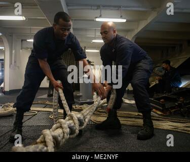 171224-N-NG 033-1092 arabischen Golf (31. 24, 2017) der Bootsmann Mate Seemann Ronnie Brown, rechts, und Seaman Deontay Braun griff Verankerungsleine während ein Meer und anker detail als der Flugzeugträger USS Theodore Roosevelt (CVN 71) in Jebel Ali, Dubai für eine regelmäßig geplante Hafen besuchen Sie zieht. Theodore Roosevelt und ihre Carrier strike Group werden in den USA 5 Flotte Bereich für Maßnahmen zur Erhöhung der Sicherheit im Seeverkehr im Einsatz Verbündeten und Partnern zu beruhigen und der Freiheit der Schiffahrt und des freien Handels in der Region erhalten. (U.S. Marine Foto von Massenkommunikation Besondere Stockfoto