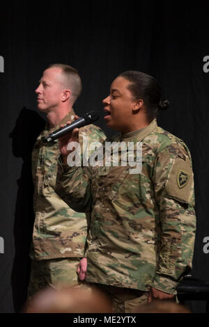 Sgt. Sanytra Johnson singt die Nationalhymne während einer Bereitstellung Zeremonie für die North Carolina National Guard's (NCNG)1-130 th Angriff Reconnaissance Bataillon (1-130 th ARB) und Det. 1B Co 638th Aviation Support Bataillon an der Hoffnung der Gemeinschaft Kirche in Raleigh, North Carolina, 17. April 2018. Fast 300 Soldaten der Einheit wird als Aviation task force battalion Hauptquartier zur Unterstützung der Operation, die die Freiheit des Sentinel über Zug, Beraten und Unterstützen den Befehl - Süden (Taac-S) zur Unterstützung der Vereinigten Staaten Streitkräfte und der afghanischen nationalen Verteidigungs- und Sicherheitskräfte dienen, um die Bedingungen zu ermöglichen Stockfoto