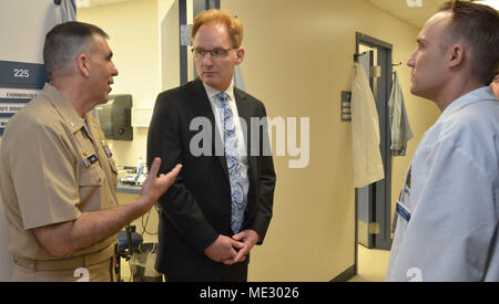 JACKSONVILLE, Fla. (16. April 2018) Unterstaatssekretär der Marine Thomas Modly (Mitte), Naval Hospital Jacksonville befehlshabenden Offizier, Kapitän Matthew Fall (links), und die Marine Zweig Gesundheit Klinik Jacksonville Zahnarzt Lt.Cmdr. Andreas Hoppe Agilität und die Rolle der zahnmedizinischen Bereitschaft in Bereitschaft während des Krieges zu diskutieren, während bei einem Besuch in der Klinik am 16. April. (U.S. Marine Foto von Jacob Sippel, Naval Hospital Jacksonville/Freigegeben). Stockfoto