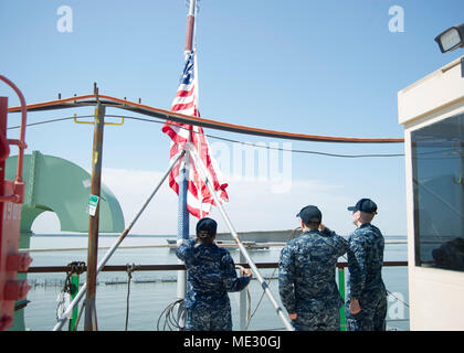 180418-SX 673-029 Newport News, Virginia (18. April 2018) Quartermaster 2. Klasse Treonia Collier, links, von Columbus, Georgia, quartiermeister 2. Klasse Christopher Malenfant, Mitte, von Bristol, Connecticut und Quartiermeister Seaman Apprentice Christopher Mynhier, vom Uba City, Kalifornien, grüßen die Hälfte Dreimaster nationalen Ensign auf dem Flugdeck der Nimitz-Klasse Flugzeugträger USS George Washington (CVN 73). Der Stern war zur Hälfte verschoben - Mast in Bezug zur Übergabe des Schiffes sponsor Barbara Bush. (U.S. Marine Foto von Mass Communication Specialist 3. Klasse Kashif Basharat/Freigegeben) Stockfoto