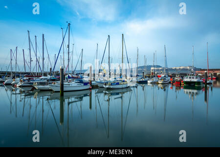 Reflexionen von Wolken und Yachten auf eine ruhige Feder Tag am Hafen von Scarborough, North Yorkshire, Großbritannien Stockfoto