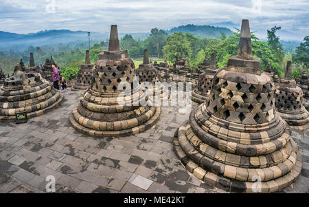 Perforierte Stupas, die Buddha Statuen auf der kreisförmigen Dachterrassen des 9. Jahrhunderts Borobudur buddhistischen Tempel, Zentraljava, Indonesien Stockfoto