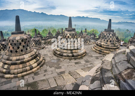 Perforierte Stupas, die Buddha Statuen auf der kreisförmigen Dachterrassen des 9. Jahrhunderts Borobudur buddhistischen Tempel, Zentraljava, Indonesien Stockfoto