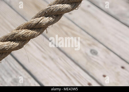 Im Alter von Seil mit Holzboden im Hintergrund eine natürliche Alter Textur für den Einsatz als Hintergrund. Stockfoto