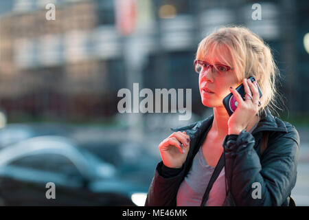 Schöne Mädchen, am Telefon zu sprechen in der Nacht auf einer belebten Straße der Stadt Los Angeles Stockfoto