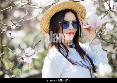 Junge Frau genießt das warme Wetter im Frühling und duftenden Magnolia Stockfoto
