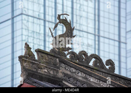 Dragon Skulptur auf Daci buddhistischen Tempel Dach gegen moderne Gebäude in Chengdu, China Stockfoto