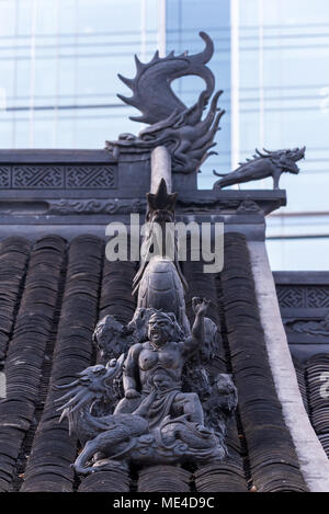 Dragon Skulptur auf Daci buddhistischen Tempel Dach gegen moderne Gebäude in Chengdu, China Stockfoto