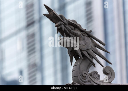 Dragon Skulptur auf Daci buddhistischen Tempel Dach gegen moderne Gebäude in Chengdu, China Stockfoto