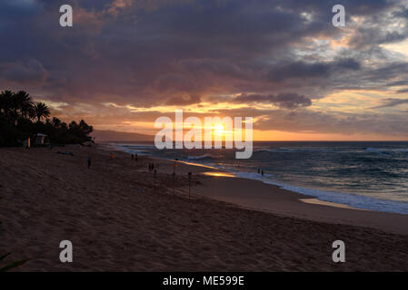 Wellen am Strand, während die Sonne unten, wie Sunset Beach Park auf der North Shore von Oahu, Hawaii geht Stockfoto