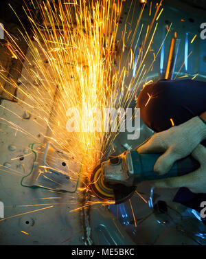 industrielle Metallbearbeitung Werkzeug in der Fabrik Shop Eisenverarbeitung und Schnitt auf Stahlblech gegen schöne Feuer Funken Stockfoto