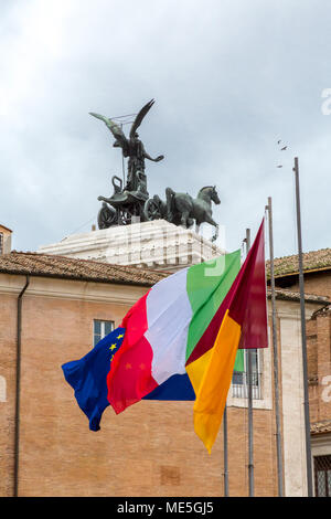 Rom, Italien, 21. Februar 2015: Europäische und italienische Flaggen fliegen hinter dem Altare della Patria an einem bewölkten nassen Tag in Rom. Stockfoto