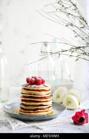 Stapel Pfannkuchen bestreut mit Puderzucker mit Himbeeren eingerichtet Stockfoto