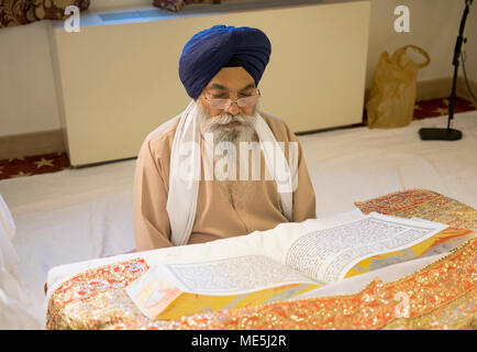 Sikh Priester, ein Granthi, lesen Sri Guru Granth Sahib, dem heiligen Buch der Sikhs. In Richmond Hill in Queens, New York. Stockfoto