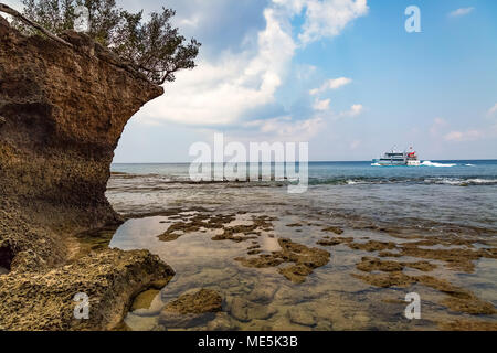 Malerische Neil Island Sea Beach Andaman mit Korallen und natürlichen Felsformationen und die Aussicht auf ein Schiff am Horizont. Stockfoto