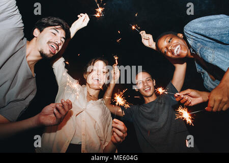 Gemischten rennen Freunde spielen mit Wunderkerzen und festliche Feier party Konzept Stockfoto