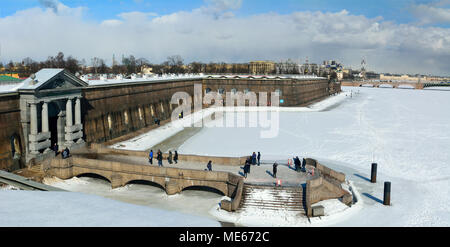 St. Petersburg, Russland - 27. März 2018. Außenansicht der Peter und Paul Festung Mauern und gefrorenen Fluss Newa, gegenüber Trinity Brücke, mit Menschen. Stockfoto