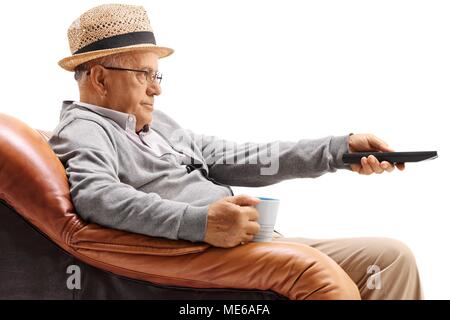 Gelangweilt älterer Mann sitzt in einem Sessel und Fernsehen isoliert auf weißem Hintergrund Stockfoto