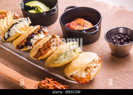 Verschiedene Arten von arepas, Fleisch, schwarze Bohnen, Käse, frittierte Kochbanane, typische Südamerikanische Lebensmittel Stockfoto