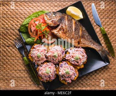 Gebratener Fisch mit gebratenen Wegerich und Salat, Strand Essen in Venezuela Stockfoto