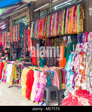 Weibliche Ladenbesitzer in Ihrer in einer Textil- Geschäfte mit bunten Stoffballen in einem Stoff Markt in Ho Chi Minh City, Vietnam. Stockfoto