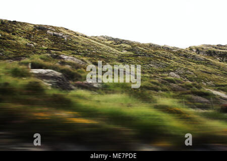 Defokussierten Hügel durch eine Autoscheibe gesehen. Getönten filter Foto. Verschwommen Aktion aus dem Auto mit hoher Geschwindigkeit. Vage Blick durch fahrendes Auto Fenster. Ring Stockfoto