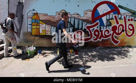 Gaza, Gazastreifen, palästinensischen Gebiet. 22 Apr, 2018. Ein palästinensischer Maler setzt die Vollendung Wandbild, aufrief, zum Boykott israelischer Waren in Gaza Stadt, am 22. April 2018 Credit: Mahmoud Ajour/APA-Images/ZUMA Draht/Alamy leben Nachrichten Stockfoto