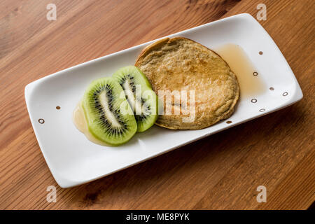 Pfannkuchen mit Kiwi und Ahornsirup (mit organischen Mehl) hausgemachte Produkte. Stockfoto