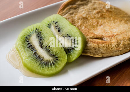 Pfannkuchen mit Kiwi und Ahornsirup (mit organischen Mehl) hausgemachte Produkte. Stockfoto