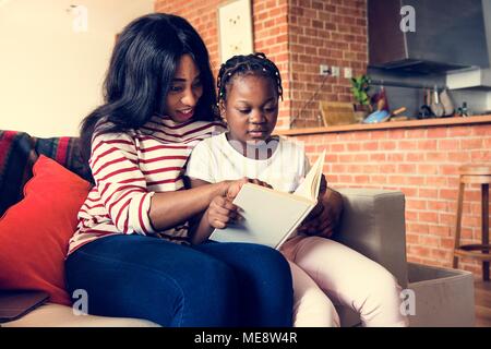 Afrikanische Mutter ihrer Tochter zu helfen, in ihrer Hausaufgaben Stockfoto