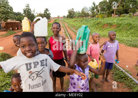 Lugazi, Uganda. 17. Mai 2017. Lächelnd ugandische Kinder laufen auf einer Bahnstrecke in einer ländlichen Gegend in Uganda. Stockfoto