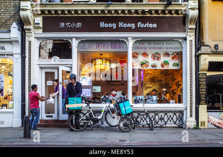 Deliveroo Lebensmittel-lieferservice Kuriere holen Sie Mahlzeiten zum Mitnehmen aus dem Hong Kong Fusion Restaurant im Zentrum von Cambridge Großbritannien Stockfoto