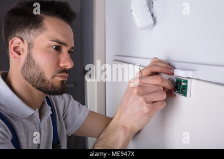 In der Nähe von einem Techniker Hand zur Festsetzung der Sicherheit System Tür Sensor Stockfoto