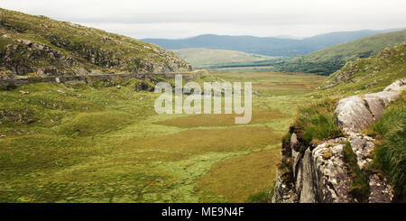Grüne Hügel und die Straße auf dem Hügel. Einen malerischen Blick auf den Kerry Mountains und der Umgebung in der Grafschaft Kerry. Im Alter von Wirkung. Landschaft entlang der R Stockfoto