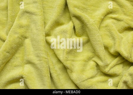 Weichen, grünen Stoff mit Wellen und Falten. Weiche textile Textur. Falten auf den weichen Stoff. Stockfoto