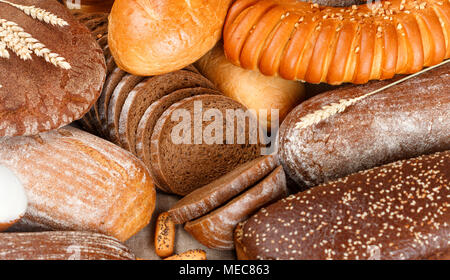 Frisch gebackene Roggen und Weizen Brot auf dem Tisch. Ganze und aufgeschnittene Brote. Essen Konzept. Selektiver Fokus Stockfoto