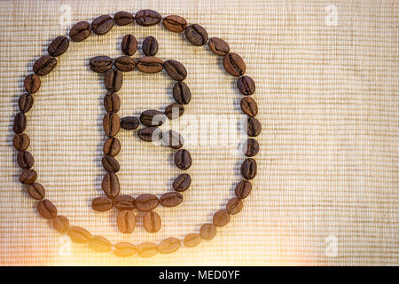 Kaffeebohnen sind in Form einer bitcoin Zeichen auf eine beige Serviette gelegt. Symbol für Wachstum und Fortschritt, Erholung, Wohlbefinden. Stockfoto