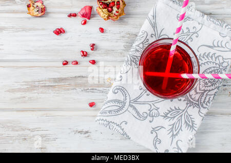 Frischen Granatapfelsaft in ein Glas mit Obst Granatäpfel auf weißem Holz- Hintergrund Stockfoto