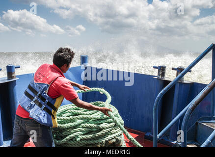 Nicaraguanische Mann bei der Arbeit auf einer Fähre nähert sich Insel Ometepe (Nicaragua, Mittelamerika) Stockfoto