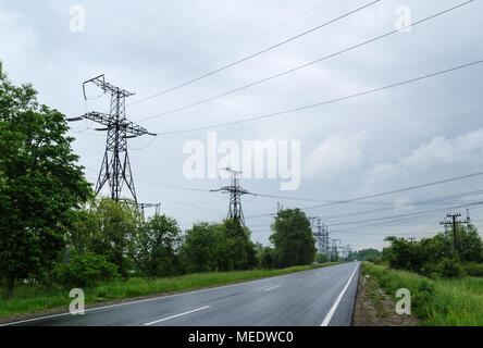 Autobahnen vorbei unter Stromleitungen hoher Spannung. Stockfoto