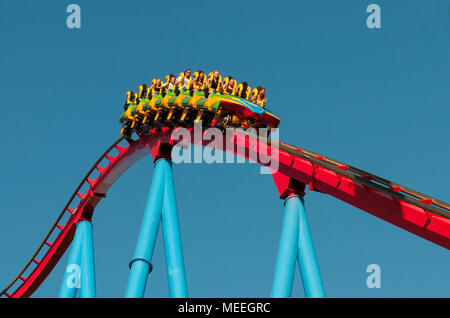 Barcelona, Spanien - 3 August 2012: Junge Menschen, die auf eine Achterbahnfahrt im berühmten Port Aventura Vergnügungspark vor blauem Himmel in Barcelona, Spanien Stockfoto